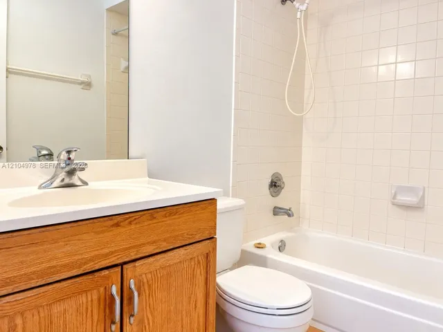 Wood-finish vanity with a white countertop and integrated sink
