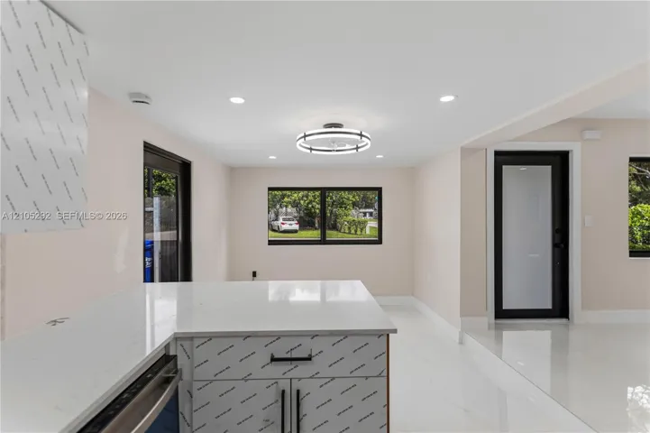 White countertop island with built-in cabinetry and matte black hardware