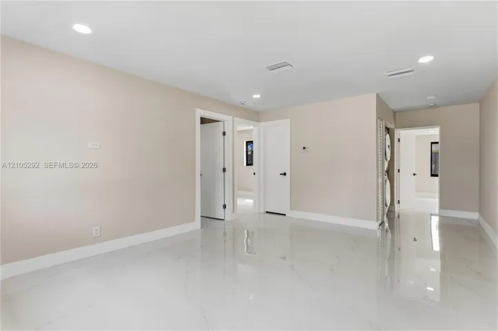 Recessed lighting illuminates the neutral wall tones and white trim