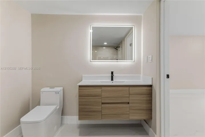 Floating wood-finish vanity with a white countertop and rectangular sink