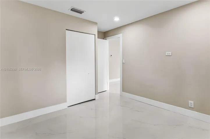 Recessed lighting illuminates the neutral wall tones and white trim