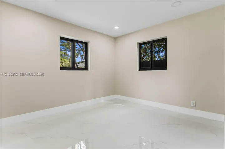 Smooth walls with a neutral finish, recessed lighting, white baseboards, and two windows with black frames