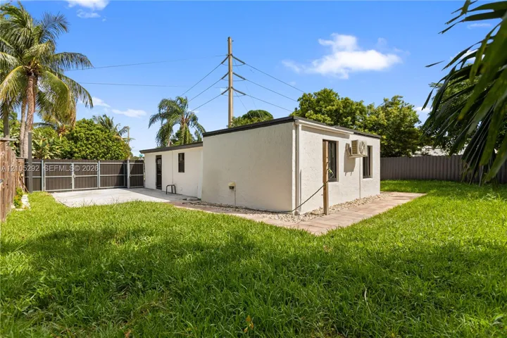 Enclosed yard with a privacy fence, concrete patio, and mature landscaping