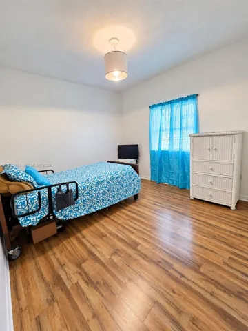 Recessed lighting, wood-finish flooring, and white walls