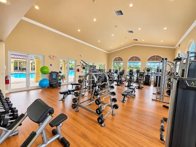 Fitness center featuring wood-finish flooring, vaulted ceilings, and extensive exercise equipment