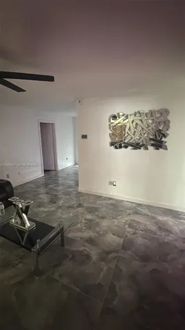 Polished concrete flooring, recessed wall lighting, and a ceiling fan with dark blades