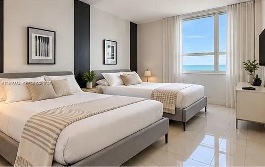 Expansive window offering ocean scenery, bright white walls, dark accent wall, and polished tile flooring