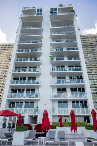 Modern high-rise with multiple private balconies featuring glass railings and floor-to-ceiling windows