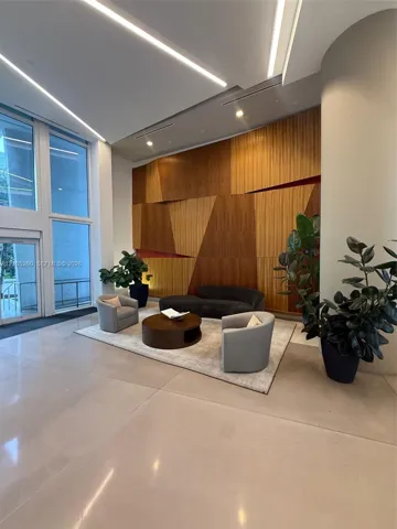 Hardwood accent wall with geometric design, recessed lighting, floor-to-ceiling windows, and polished concrete flooring