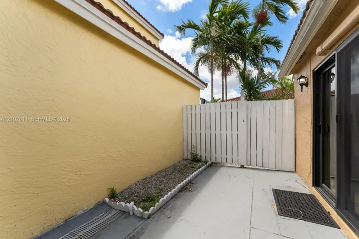 Exterior patio with a privacy fence, stucco siding, and a sliding glass door