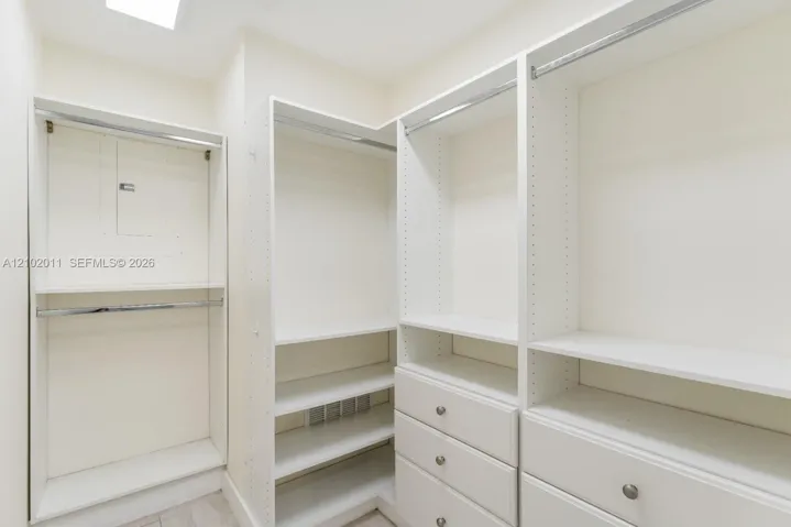 Custom closet system with multiple hanging rods, integrated shelving, and built-in drawers