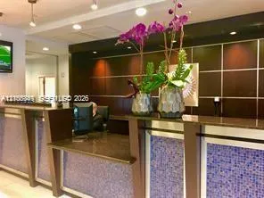 Reception counter with a dark countertop and blue mosaic tile accents