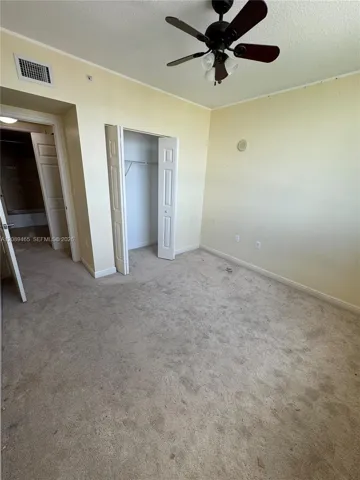 2nd bedroom (could be a den/office/baby room /zen room etc...Neutral-toned room featuring carpeting, a ceiling fan with integrated lighting, and a bi-fold door closet