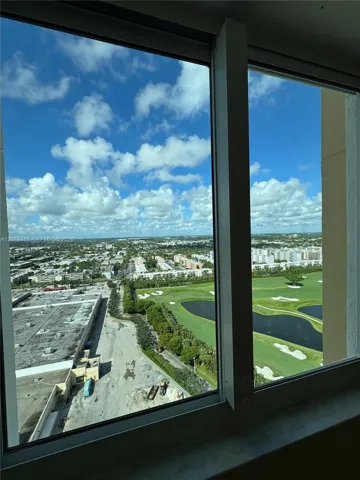 bedroom view featuring panoramic urban scenery and golf course landscapes