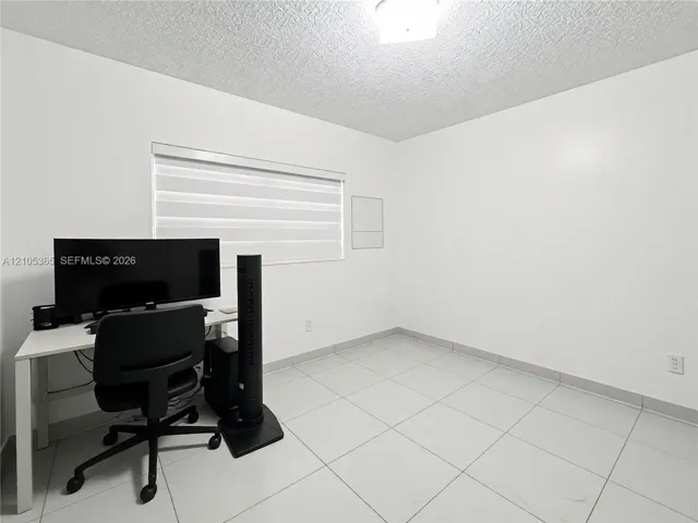 Recessed window with horizontal blinds, overhead lighting fixture, and tile flooring