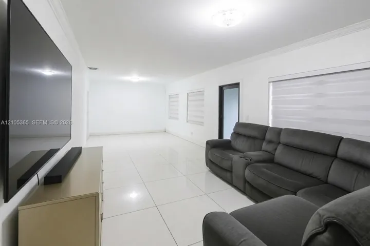 Spacious interior with white tile flooring and crown molding