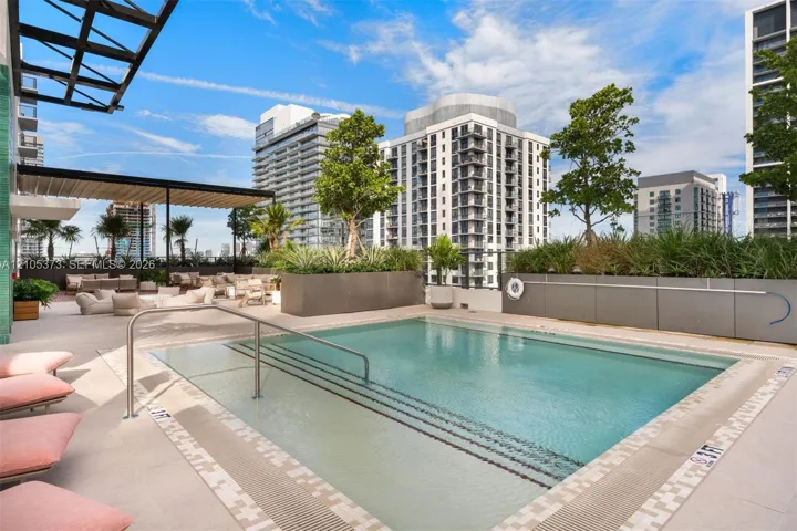 Rooftop pool with integrated steps, surrounded by a paved deck and integrated planters