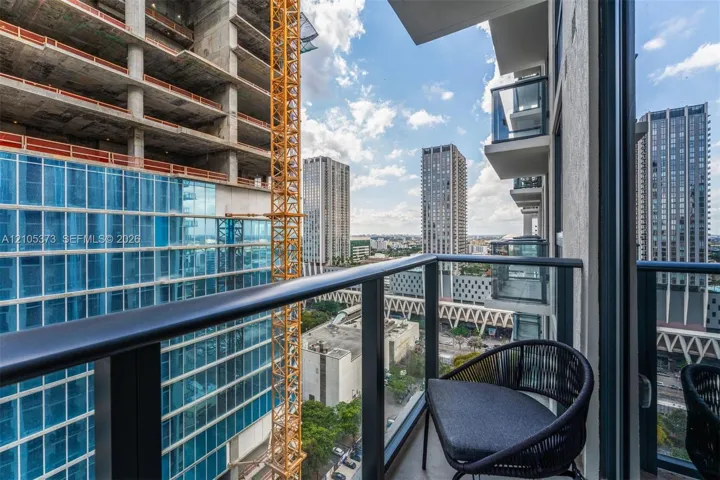 Balcony with glass railings and a sliding glass door
