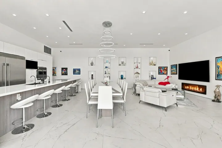 Open-concept living space with large format tile flooring, a modern linear fireplace, and built-in shelving
