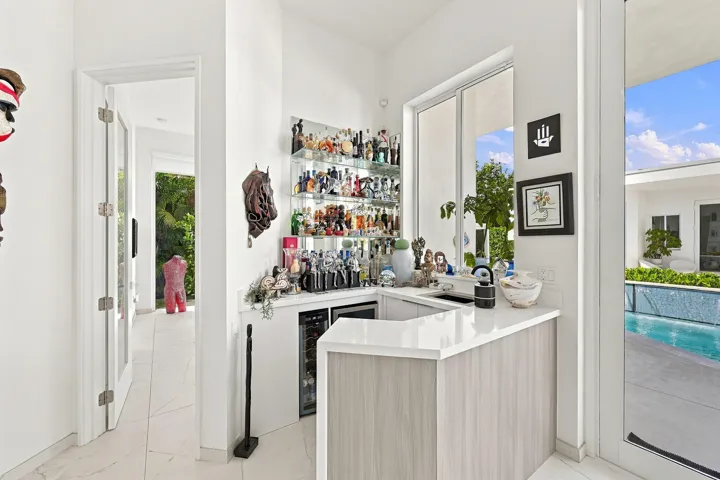 Built-in wet bar with a white countertop and wood-finish cabinetry