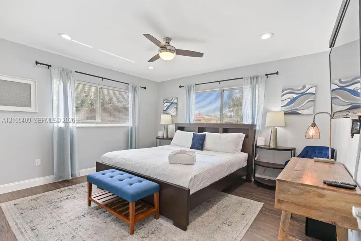 Recessed lighting, ceiling fan, wood-finish flooring, two windows, and light gray wall paint
