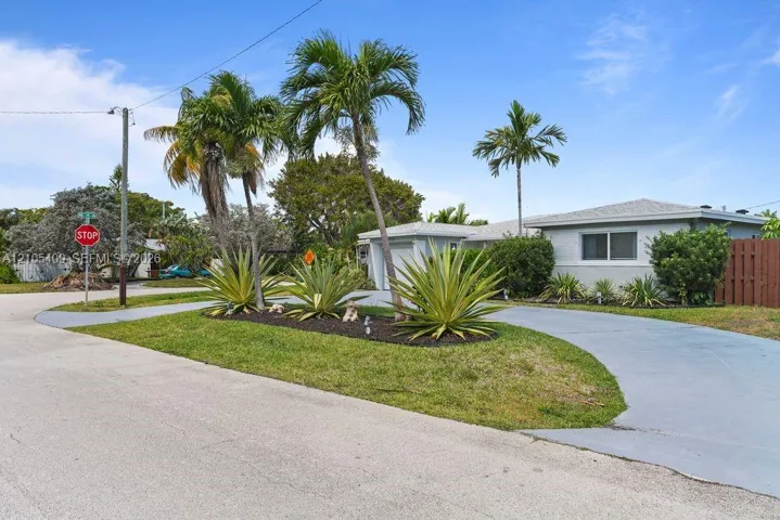 Single-story residence with a light-colored exterior, an attached garage, and a paved driveway