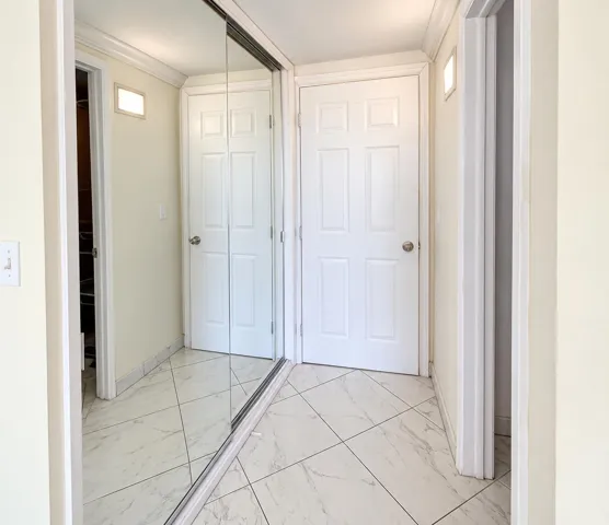 White paneled doors, crown molding, and tiled flooring