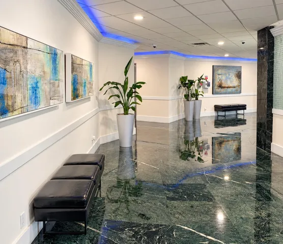 Polished green marble flooring, recessed ceiling lighting, crown molding, and wainscoting