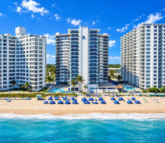 Beachfront high-rise buildings with expansive balconies and a ground-level pool deck