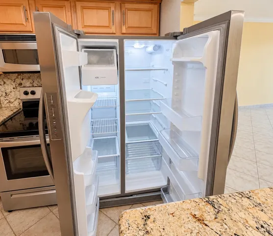 Stainless steel side-by-side refrigerator, built-in microwave, and electric range