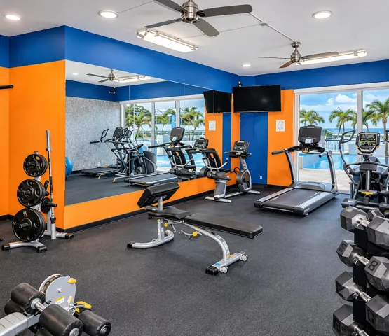 Fitness center with floor-to-ceiling windows, recessed lighting, and ceiling fans