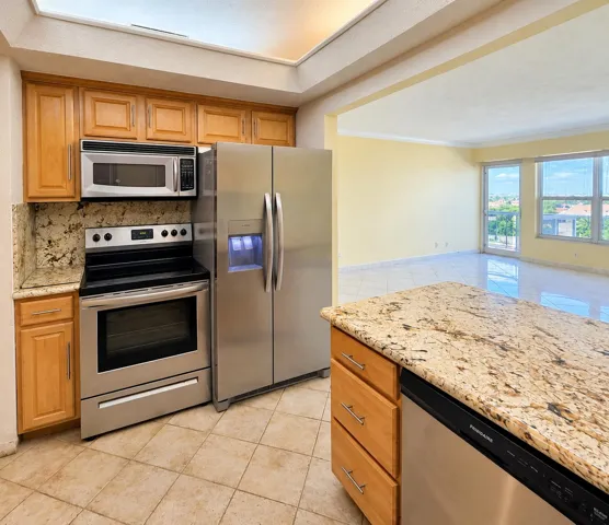 Kitchen featuring wood cabinetry, stainless steel appliances, and stone countertops
