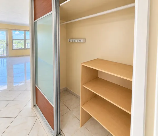 Built-in closet with sliding doors, interior shelving, and a hanging rod