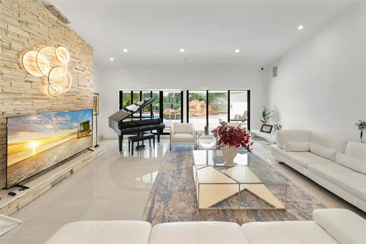 Polished tile flooring, a stacked stone accent wall, recessed lighting, and expansive sliding glass doors
