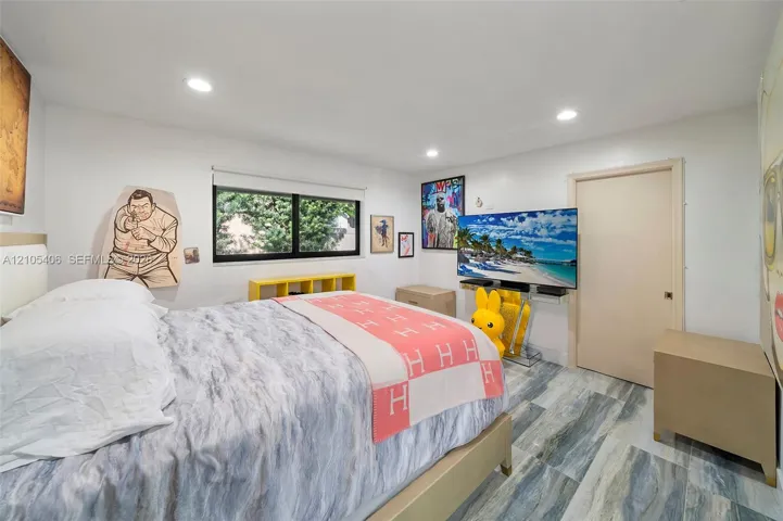 Recessed lighting, wood-finish flooring, a built-in shelf, and a large window with roller shades