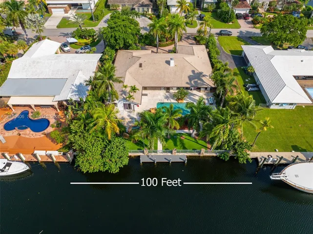 Waterfront property featuring a private boat dock, in-ground swimming pool, and extensive paved patio
