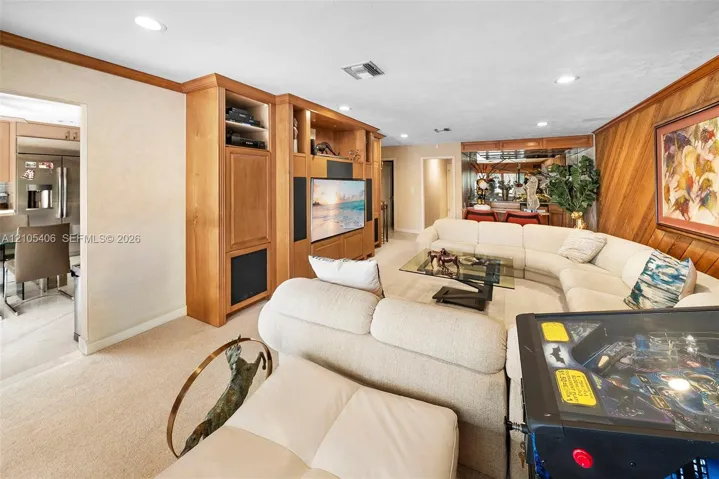 Built-in entertainment cabinetry with wood-finish paneling, recessed lighting, and wood-paneled accent wall