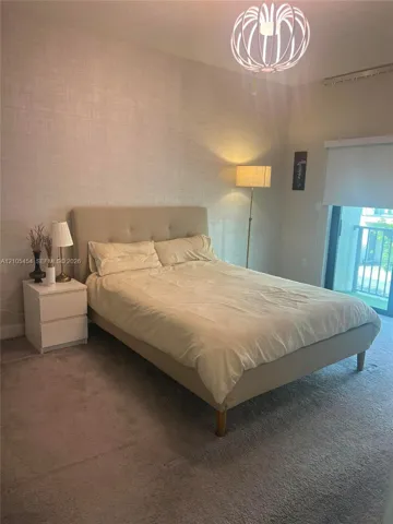 Plush carpeted flooring, textured wall covering, and a modern geometric ceiling light fixture