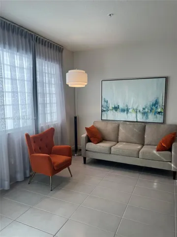 Tile flooring with light grout lines, ceiling-mounted light fixture, and floor-to-ceiling sheer curtains