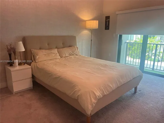 Carpeted flooring, glass sliding door, and a private balcony with railing