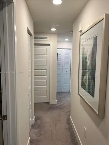 Recessed lighting, plush carpeting, white interior doors, and crisp white trim