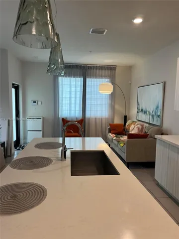 Kitchen island featuring a built-in undermount sink with a gooseneck faucet