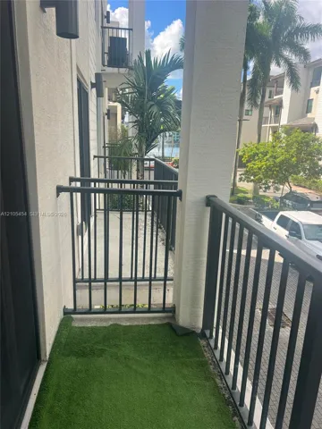 Balcony with metal railings, outdoor wall sconces, and a partial water scene