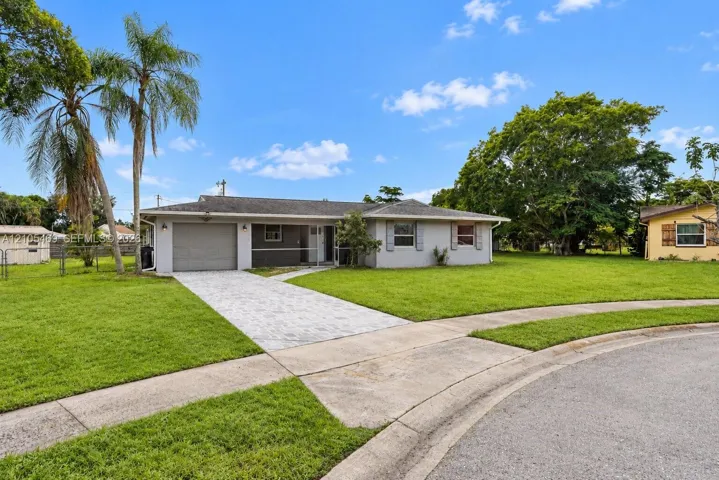 Single-story residence featuring a paved driveway, attached garage, and mature​​‌​​​​‌​​‌‌​‌‌​​​‌‌​‌​‌​‌​​​‌​​ landscaping