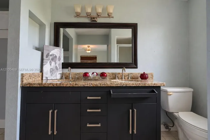 Double vanity with a granite-style countertop, dual undermount sinks, and a dark wood-finish cabinet