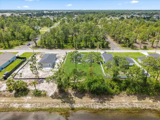 Expansive lot with partial land clearing, partially wooded surroundings, and a water frontage