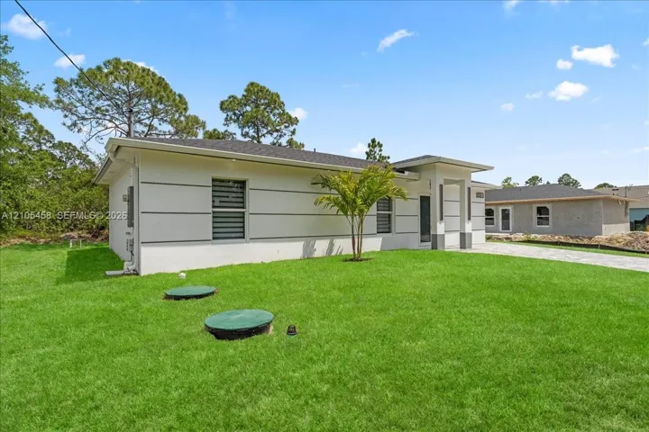 Modern exterior with white siding, dark gray accents, and a covered entry