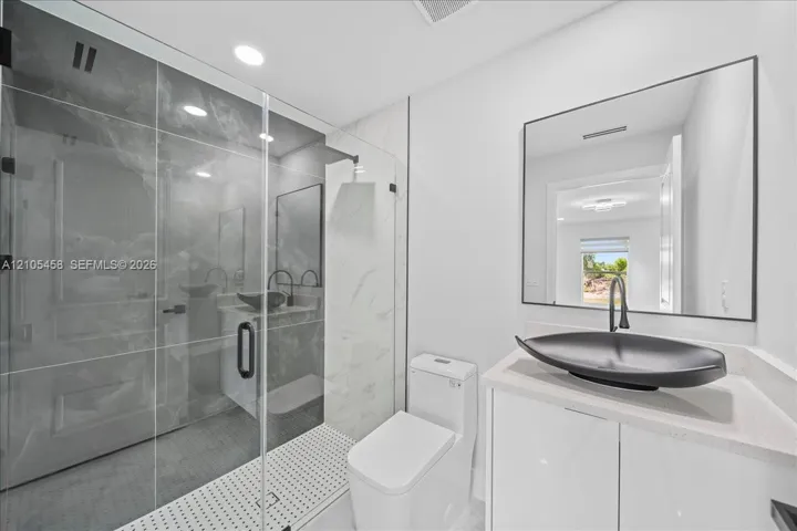 Glass-enclosed shower with large format tile surround