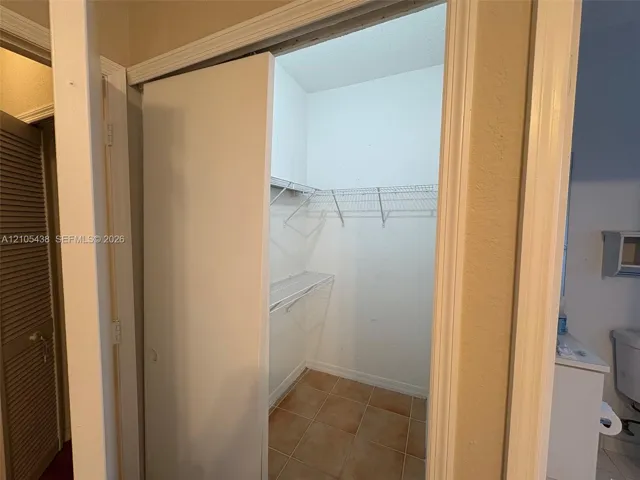 Closet with wire shelving system and terracotta-style floor tiling