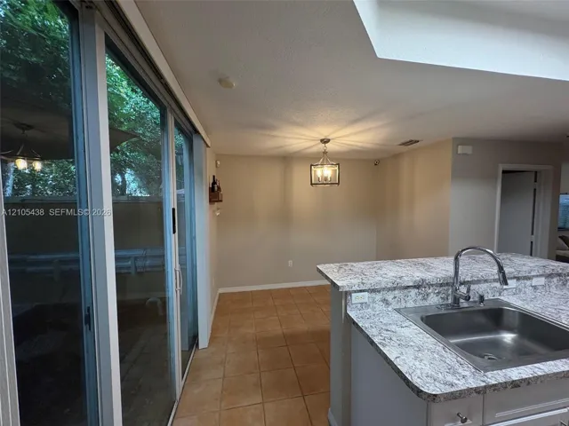 Kitchen island with an undermount sink, gooseneck faucet, and light-toned countertop